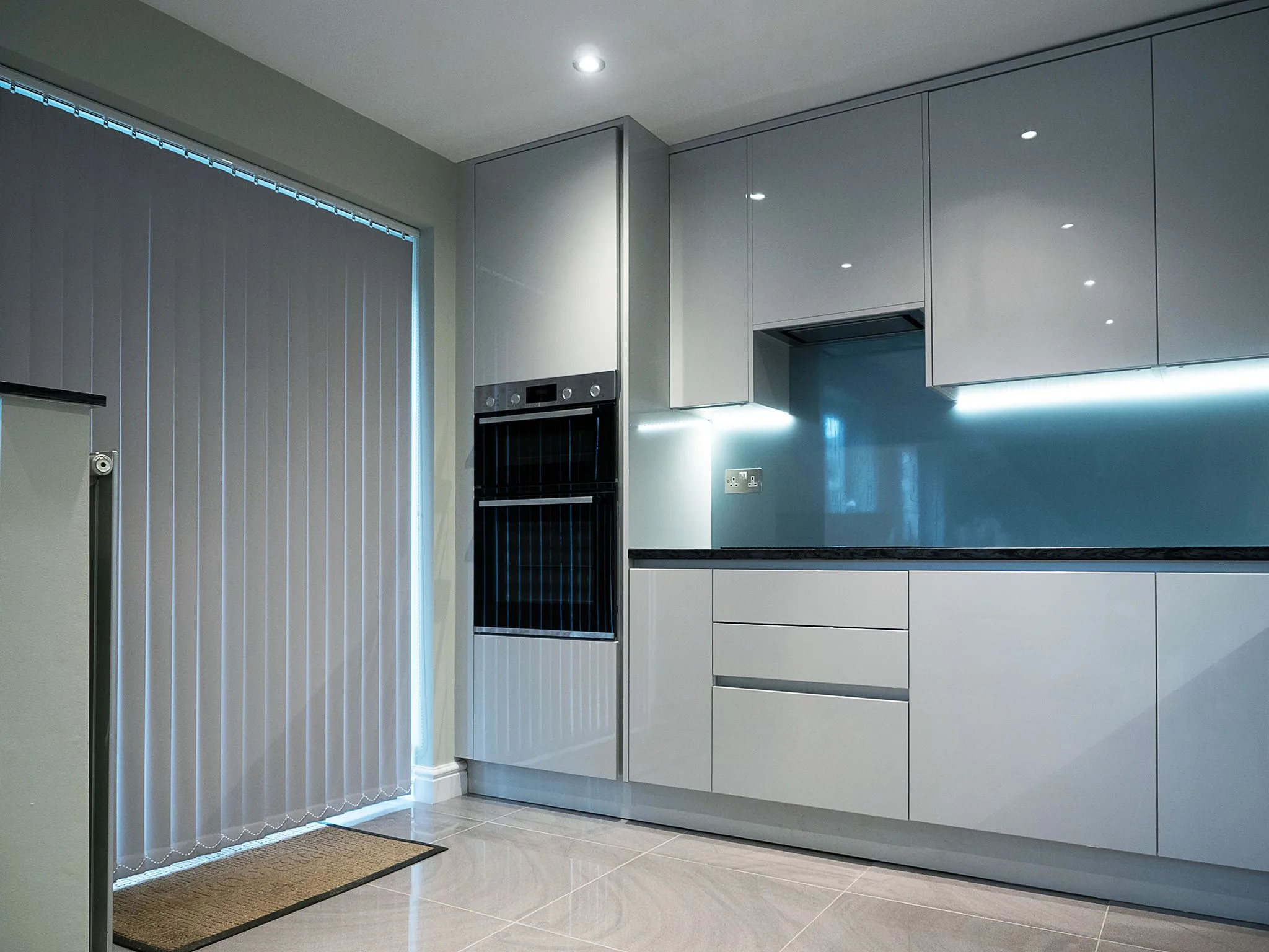 Modern kitchen installation — sleek grey gloss units with LED lighting